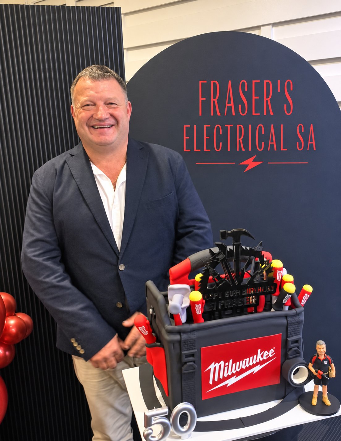 Fraser celebrating his 50th birthday in front of a Fraser's Electrical SA backdrop