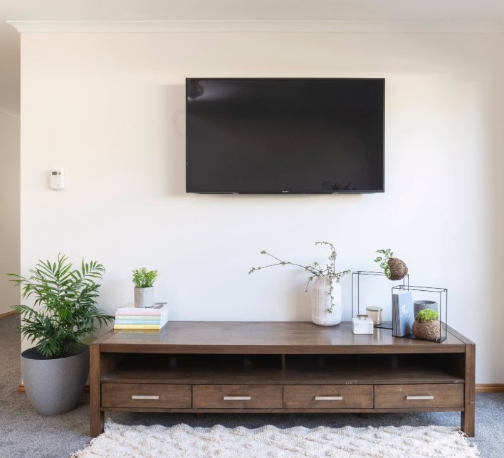 Wall-mounted TV with hidden cabling above a media unit